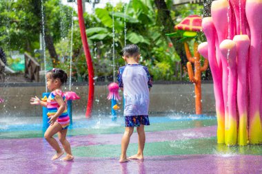 Mutlu çocuk ve kız suyun tadını çıkarıyorlar. Su parkında yaz tatili.