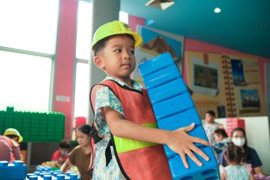 Anaokulu Asyalı çocuk oyun makinisti mekanik bina işçisi renk bloğu bina kapalı oyun alanı