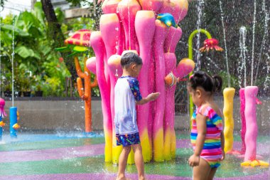 Mutlu çocuk ve kız suyun tadını çıkarıyorlar. Su parkında yaz tatili.