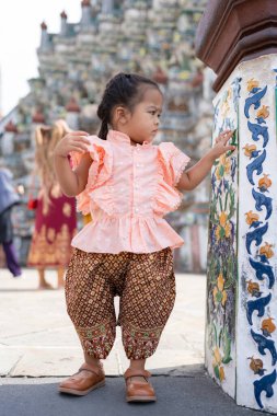 Çok tatlı bir anaokulu kızı Wat Arun 'da Tayland tarzı kostüm giyer Bangkok Tayland' ı gezer.