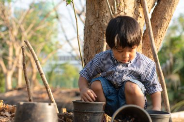 Asyalı anaokulu çocuğu gün batımında şehir parkında eğleniyor.