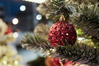 Çam ağacının dalındaki Noel balosu arka planda bulanıklaştı Mutlu yıllar