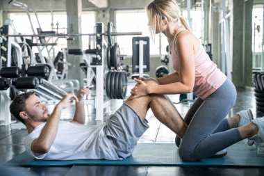 Spor çifti spor salonunda birlikte oturur erkek ve kadın egzersizi yapar.