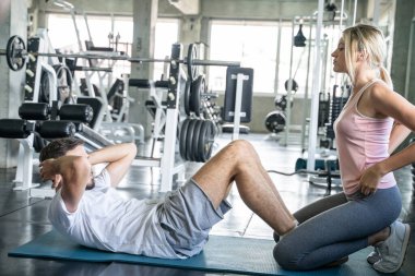 Spor çifti spor salonunda birlikte oturur erkek ve kadın egzersizi yapar.