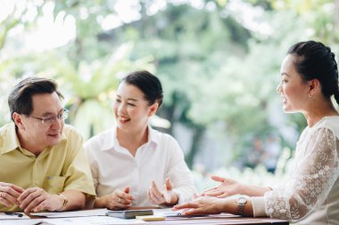 Confident mature business professional woman talking to  colleague at office table in business meeting for planning, communication and ideas. Teamwork, collaboration and female workers in conversation