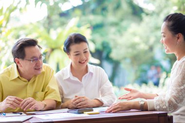 Confident mature business professional woman talking to  colleague at office table in business meeting for planning, communication and ideas. Teamwork, collaboration and female workers in conversation