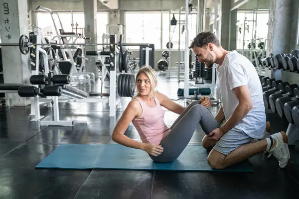 Sport couple sit up together in fitness gym man and woman exercise together