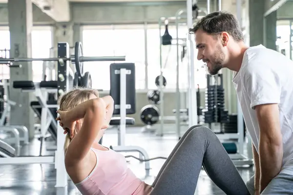 Spor çifti spor salonunda birlikte oturur erkek ve kadın egzersizi yapar.