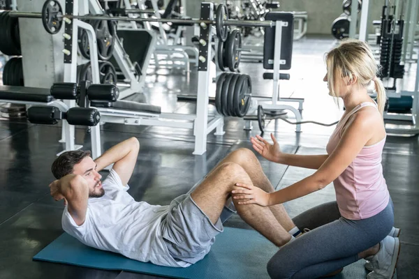 Sport couple sit up together in fitness gym man and woman exercise together