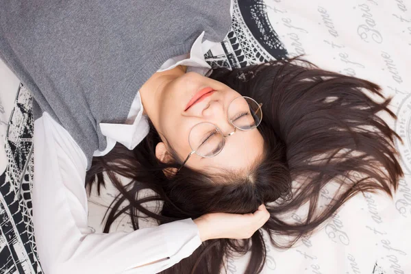 Gözlük kadın yatakta beyaz battaniye yatarken rahatlayın