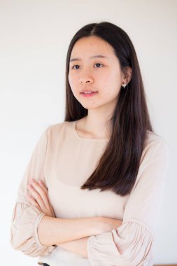 Güzel Asyalı uzun saçlı, 20 'li yaşlarda beyaz arka planda kadın portresi güzel bir iş kadını.