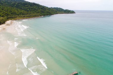 Hava manzaralı beyaz kumsal dalgalı turkuaz su, yaz tatili konsepti, doğa manzarası.