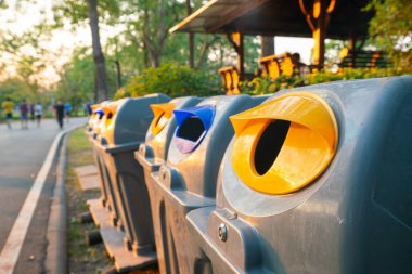 Şehir parkındaki çeşitli renkli çöp bidonları insanların geçmişini bulanıklaştırıyor.