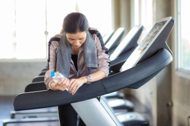 Spor yapan kadınlar spor salonunda koşu bandında koşan kadınlar yandıktan sonra su içerler.