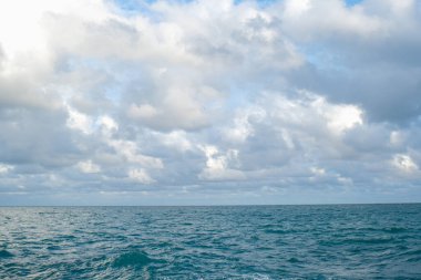 Tropik deniz sahili dalgaları mavi gökyüzüne karşı yumuşak bulutlu doğa manzarası