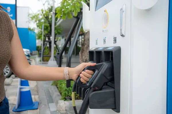 Smart business asian woman use ev car charge in ev station travel trip sustainable energy concept