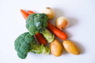 Beyaz arka plan üzerinde yeşil brokoli sarı kabak ve turuncu havuç sebze Grubu