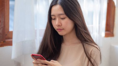 İş kadını Asyalı akıllı telefon telekomünikasyon online pazarlama elini ev ofisini kapatırken kullanıyor