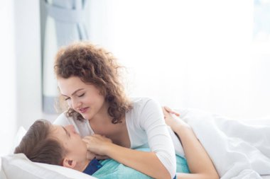 Aşk çifti sabah beyaz yatakta uzanıyor. Mutlular ve birbirlerine sarılıyorlar. Sevginin rahatlığı.