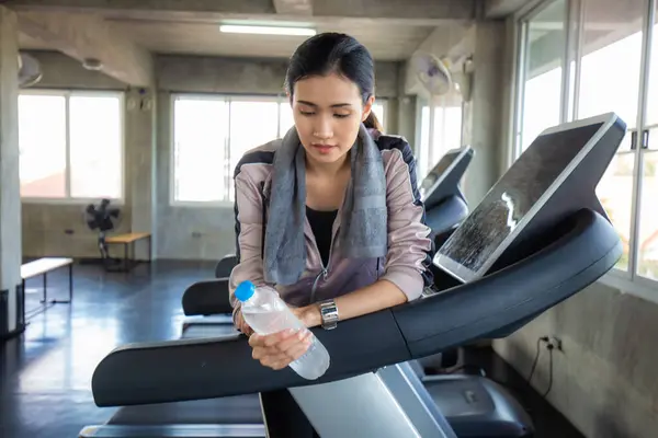 Sport women leisure and drink water after burn running on treadmill Women in gym