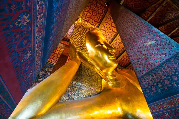 Golden big reclining buddhist statue in temple sightseeing in Bangkok thailand