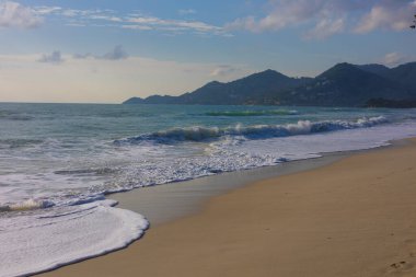 Deniz sahili beyaz turkuaz su dalgası kumsal mavi gökyüzü bulutlu doğa manzarası
