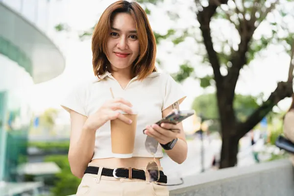 Smart business asian woman drink coffee use smartphone in city business office building outdoor recreation business woman