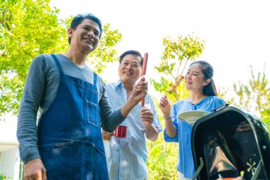 Bir grup kıdemli erkek arkadaş BBQ barbekü partisi ev bahçesinde mutlu emeklilik