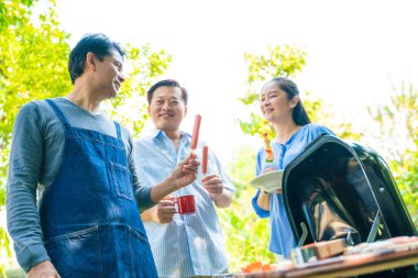 Bir grup kıdemli erkek arkadaş BBQ barbekü partisi ev bahçesinde mutlu emeklilik