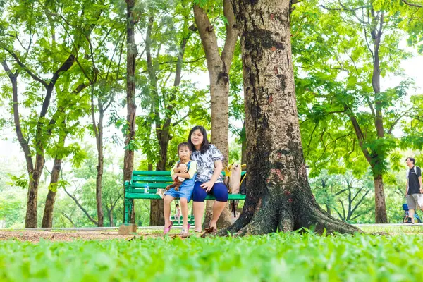 Küçük sevimli Asyalı kız şehirde rahatla. Yeşil Park 'ta anne ile açık hava aktivitesi yap.
