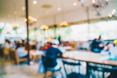 Kafenin arka planında bulanık şarap içen insanların olduğu soyut, bulanık bir kahve dükkanı.