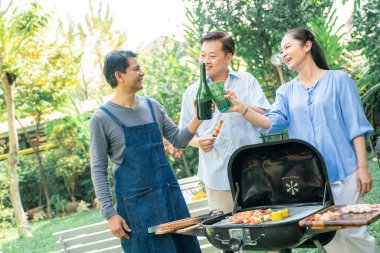 Bir grup kıdemli erkek arkadaş BBQ barbekü partisi ev bahçesinde mutlu emeklilik