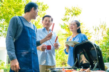 Bir grup kıdemli erkek arkadaş BBQ barbekü partisi ev bahçesinde mutlu emeklilik