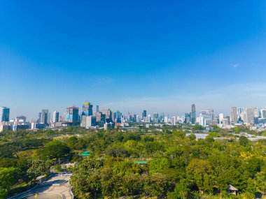 Bangkok Tayland şehir merkezindeki Benchakitti halk parkında tropik yeşil ağaç parkı olan modern ofis binası.