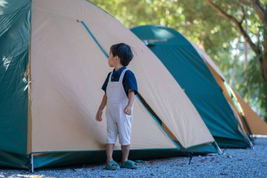 Mutlu anaokulu 5 yaşındaki Asyalı çocuk yağmur ormanları kamp alanında kamp yapıyor doğa tatilinde.