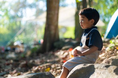 Mutlu anaokulu 5 yaşındaki Asyalı çocuk yağmur ormanları kamp alanında kamp yapıyor doğa tatilinde.