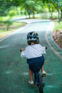 Anaokulundaki çocuk bisiklet parkında pratik yapıyor.