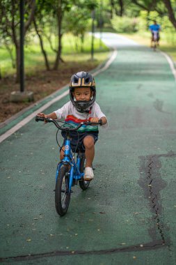 Anaokulundaki çocuk bisiklet parkında pratik yapıyor.