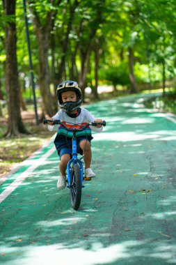 Anaokulundaki çocuk bisiklet parkında pratik yapıyor.