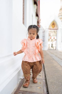 Anaokulu kızı Wat Arun 'da Tayland tarzı kostüm giyer Budist tapınağı gezer Bangkok Tayland' ı gezer.