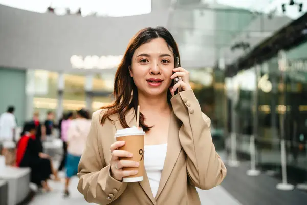 Business asian entrepreneur smart woman drink coffee on office building background woman in city