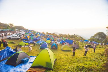 Dağ tepesinde renkli kamp çadırları. Gün doğumu manzaralı doğa macerası.