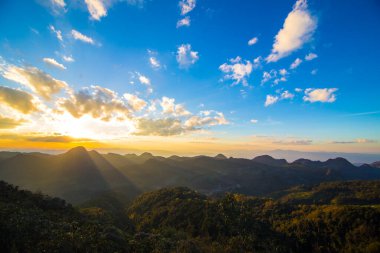 Renkli, görkemli günbatımı gökyüzü, dağların tepesinde doğa manzarası ormanı bulutu.