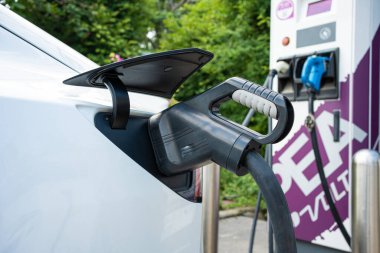 Güç kaynağı EV yakıt prizi hibrit arabada şarj için elektrikli araca bağlanıyor. Teknoloji endüstrisi yükleniyor