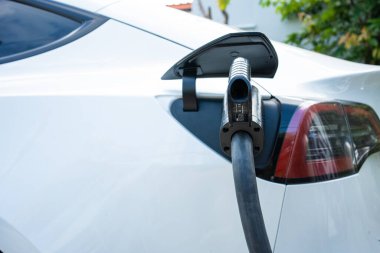 Güç kaynağı EV yakıt prizi hibrit arabada şarj için elektrikli araca bağlanıyor. Teknoloji endüstrisi yükleniyor