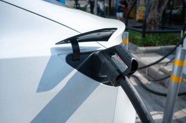 Güç kaynağı EV yakıt prizi hibrit arabada şarj için elektrikli araca bağlanıyor. Teknoloji endüstrisi yükleniyor