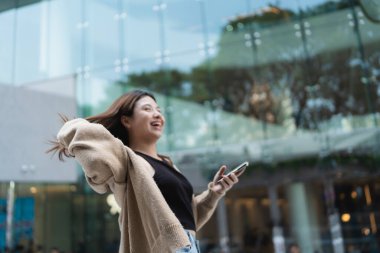 Business asian woman use smartphone internet connection in modern office city building casual business woman