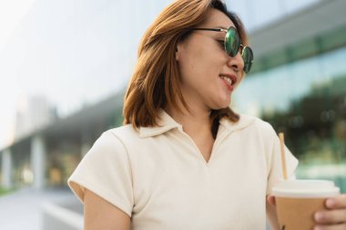 Asyalı beyaz yakalı iş kadını ofis dışında duruyor ve modern iş kadını yaratıyor.
