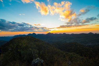 Dağın tepesinde gün batımı tropikal orman renkli gökyüzü bulutu, doğa manzarası silueti