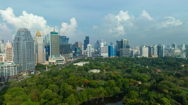 Yeşil halka açık park Lumpini Bangkok Tayland 'lı havacılık manzaralı ofis binası.